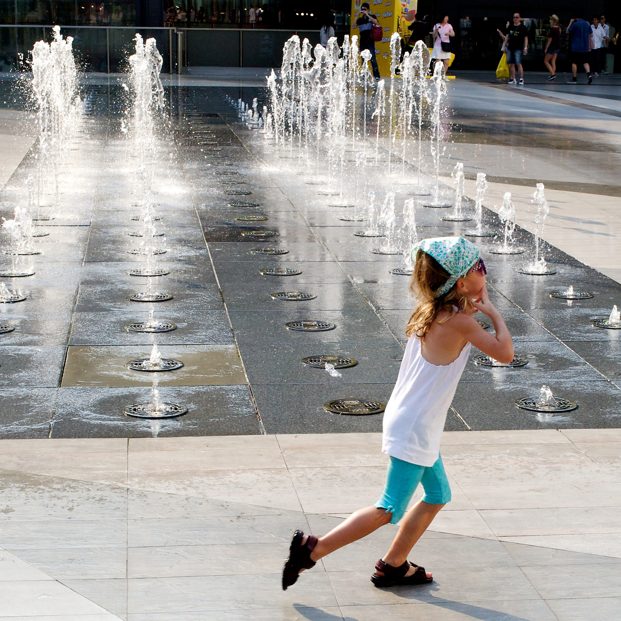 small girl playing in fountain