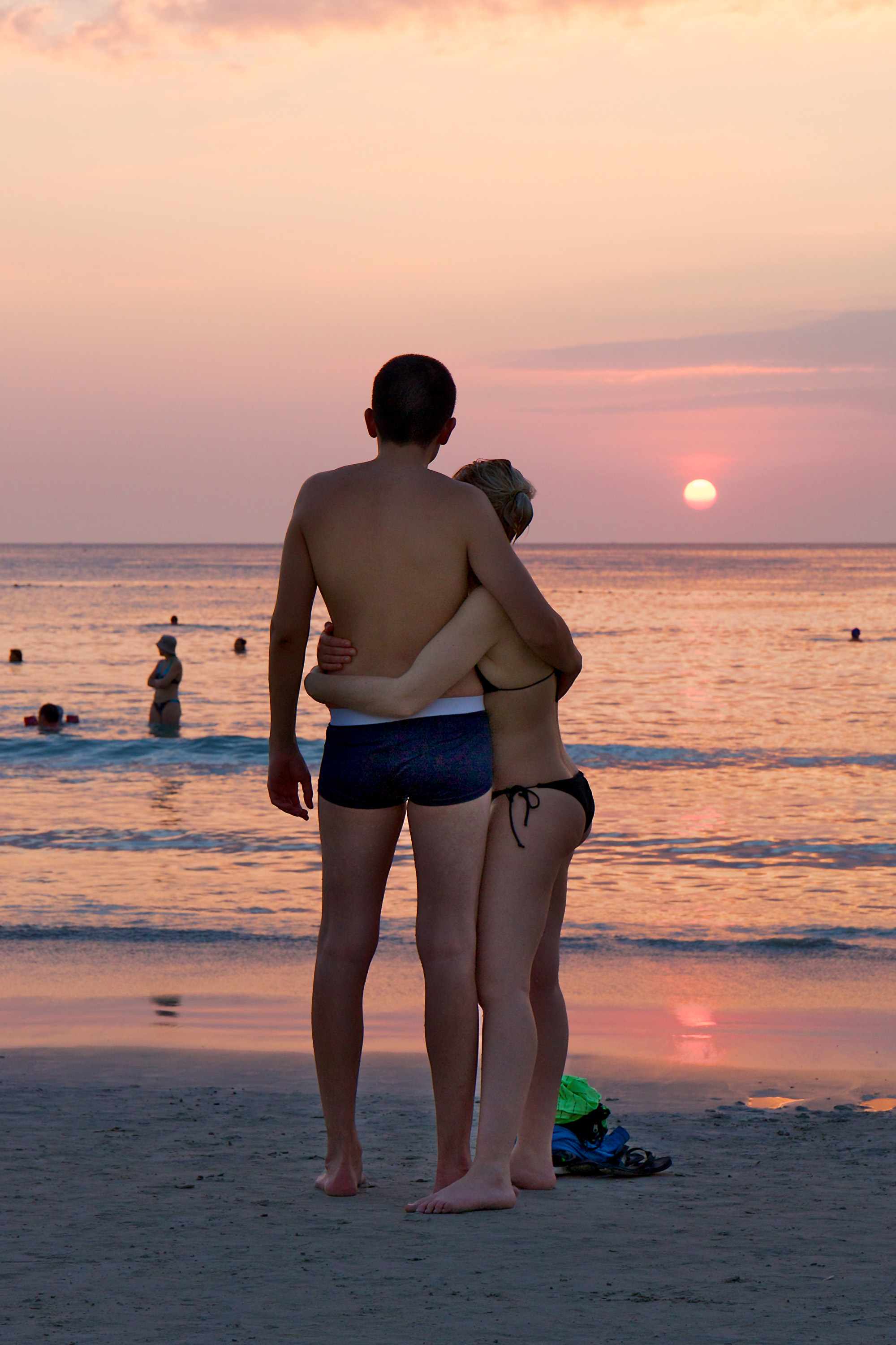 Couple on the beach, watching sunset